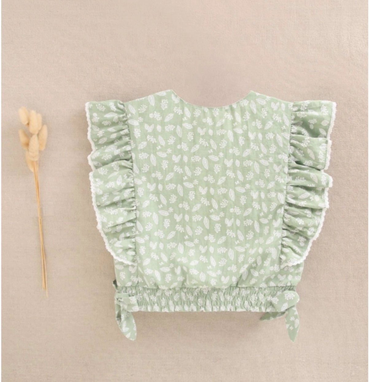 BLUSA DE NIÑA VERDE CON ESTAMPADO DE HOJAS Y VOLANTES LATERALES