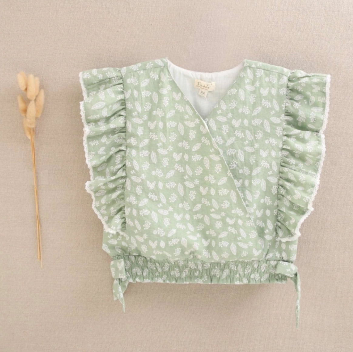 BLUSA DE NIÑA VERDE CON ESTAMPADO DE HOJAS Y VOLANTES LATERALES